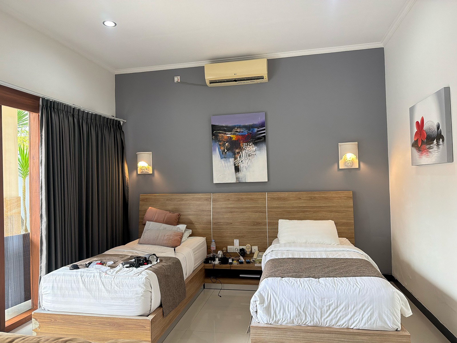 A twin room with two beds made up white, a framed print between the bedside lamps
